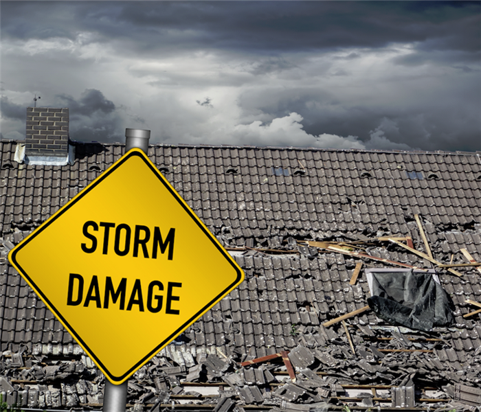 a storm damaged house with a yellow storm damage sign in front of it